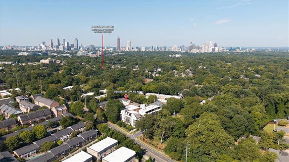 Wide aerial view of a suburban area with city skyline in the distance.