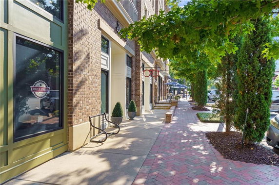 Street view of a building with brick facade and storefronts.