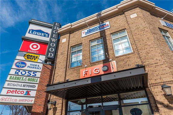 Front view of a commercial building with various store signs.