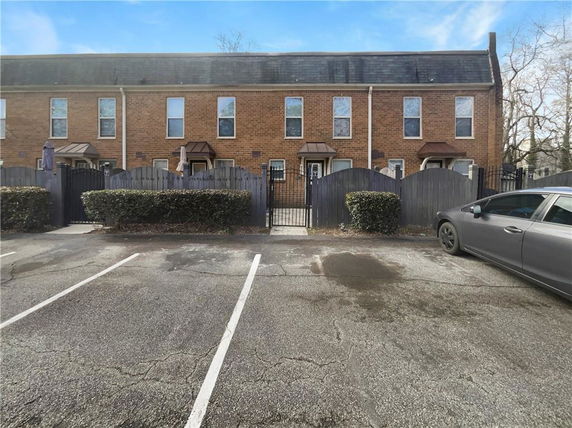 Front view of a two-story brick townhouse with multiple entrances.
