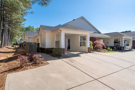 Front view of a single-story house with a driveway and covered porch.