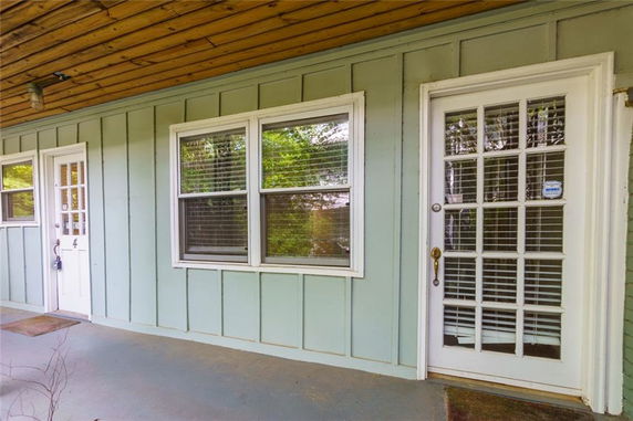 Front view of a house with French doors and wooden paneling.
