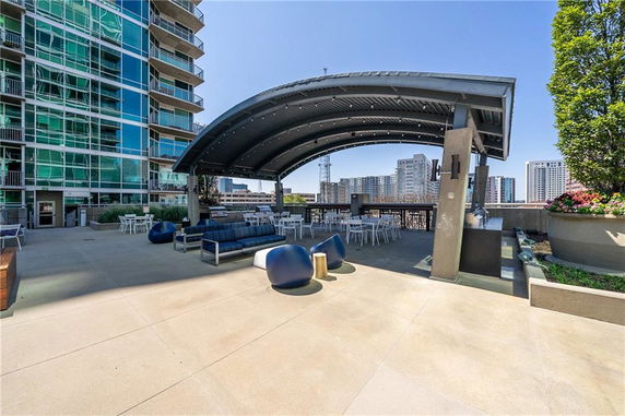Rooftop area with seating and a curved metal canopy on a building.