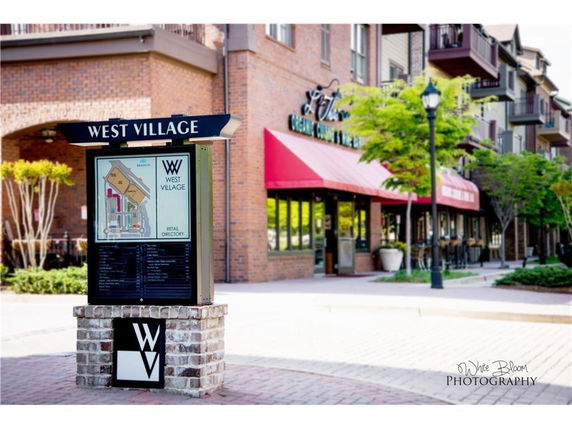 Front view of a commercial building with a directory sign labeled 'West Village'.