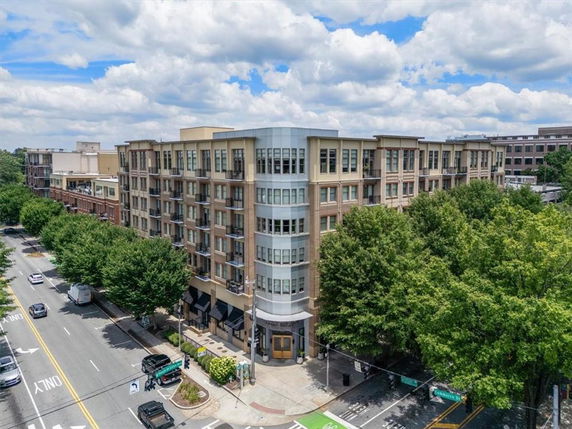 Front view of a multi-story apartment building on a street corner.