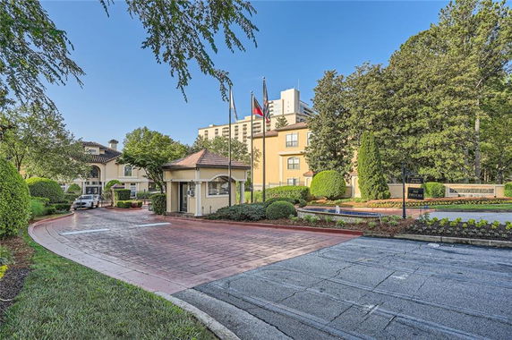 Front view of a multi-story building with flags in a landscaped area.