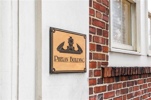 Partial view of a building with a sign reading 'Phelan Building' on a brick and concrete exterior.