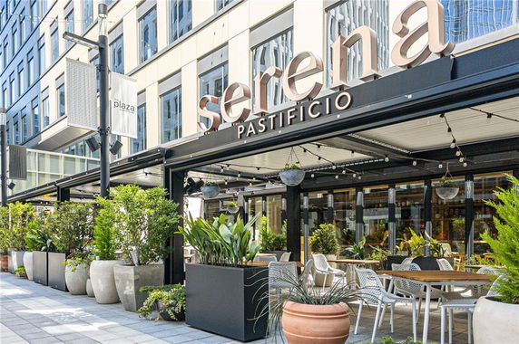 Front view of a building with a restaurant featuring outdoor seating.