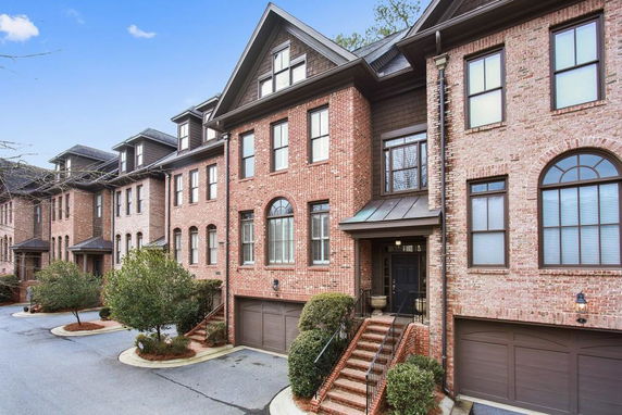 Front view of a brick townhouse with multiple levels and a garage.