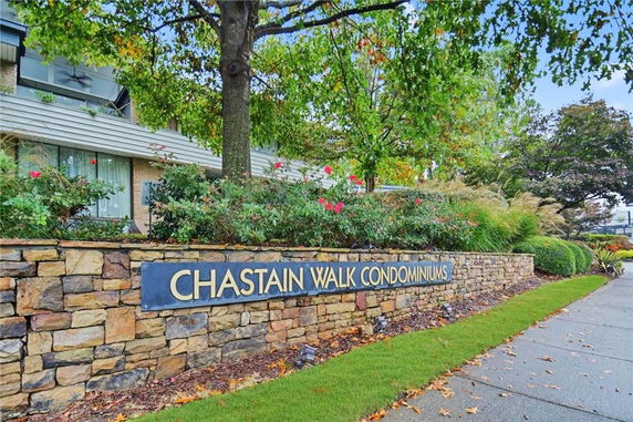 Front view of Chastain Walk Condominiums with a stone wall and garden.