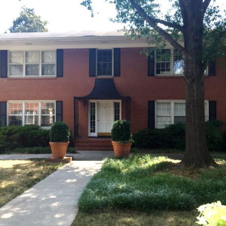 Front view of a two-story brick house with a central entrance.