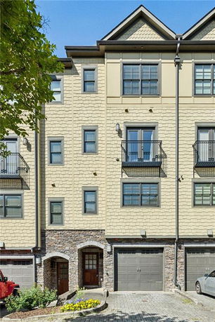 Front view of a multi-story townhouse with a garage.