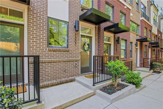 Front view of a modern townhouse with brick exterior and multiple windows