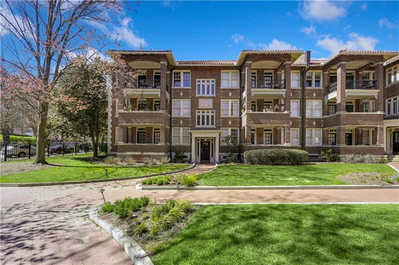 Front view of a multi-story brick apartment building with balconies.