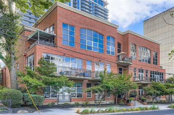 Front view of a multi-story brick building with large windows and balconies.