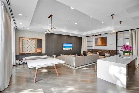 Interior view of a club house with a ping pong table, seating area, and modern decor.