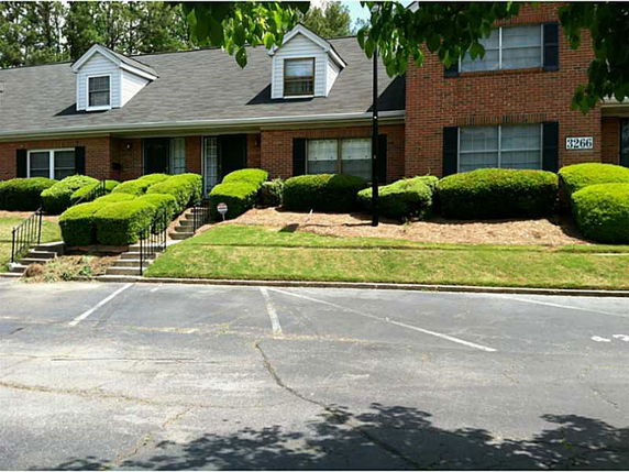 Front view of a brick building with dormer windows and front entrances.