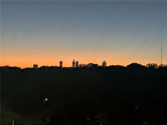 Skyline view at sunset with visible city buildings in the distance.