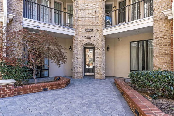 Entrance to a management office in a brick building with balconies.