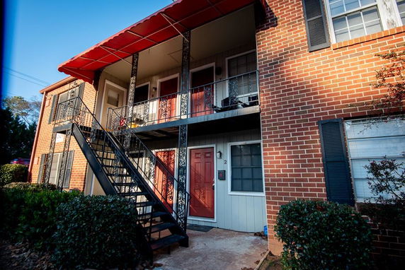 Front view of a brick apartment building with external stairs and balconies.