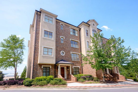 Front view of a multi-story brick and stucco building with trees nearby.