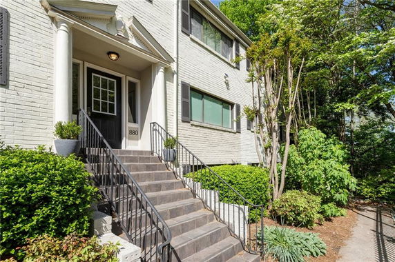 Front view of a two-story house with steps leading to the entrance.