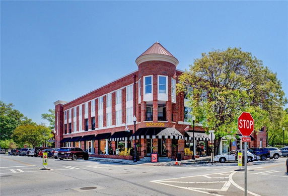 Front view of a three-story brick commercial building on a street corner.