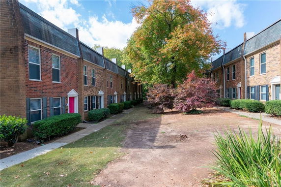 Elevated view of a row of two-story brick townhouses with adjacent walkways.