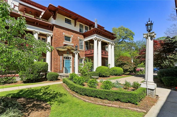 Front view of a two-story building with columns and a blue door.