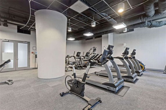 Interior view of a gym area with exercise equipment like treadmills and stationary bikes.