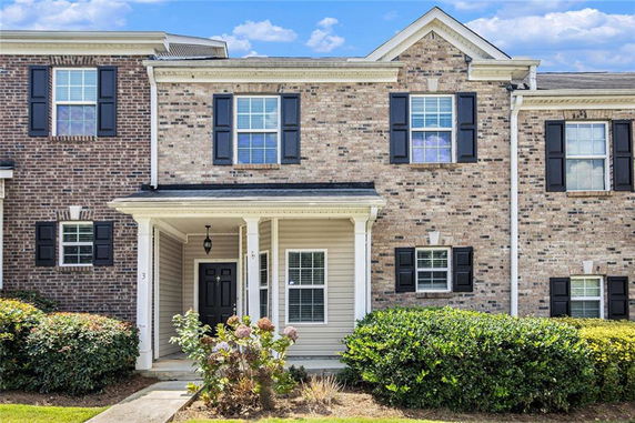 Front view of a two-story townhouse with brick and siding exterior.