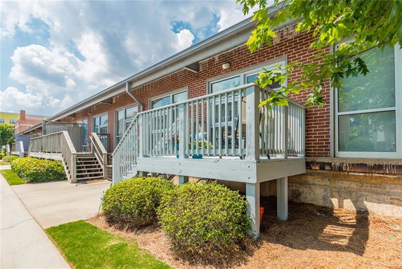 Front view of a single-story brick building with a small wooden deck and stairs.