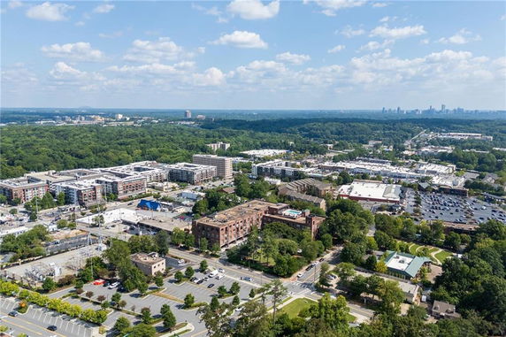 Panoramic view of a cityscape with buildings and greenery under a blue sky.