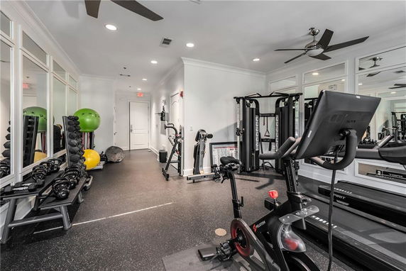 Indoor gym area with exercise equipment, including stationary bikes and weights.