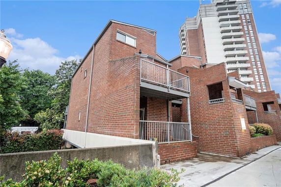 Front view of a multi-story brick building with balconies.