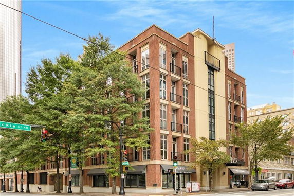 Front view of a multi-story brick building on a street corner.