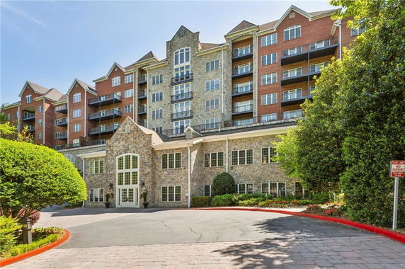 Front view of a multi-story residential building with brick and stone facade.