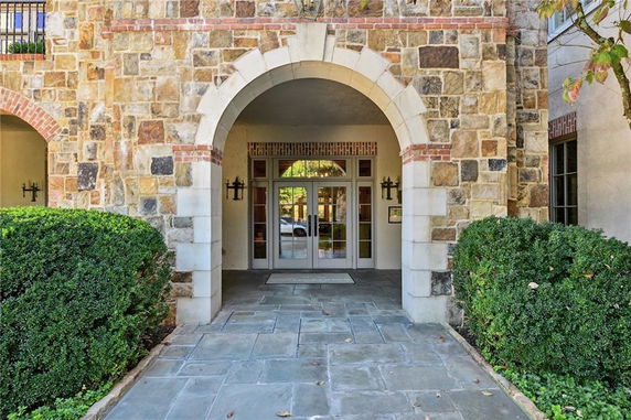 Front view of a building entrance with archway and stone facade.