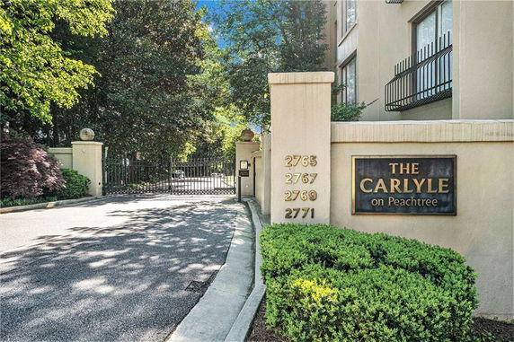 Front view of a residential complex with gated entrance and building signage.