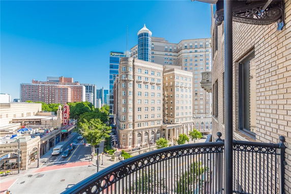 View from a balcony showing a multi-story building in an urban area.