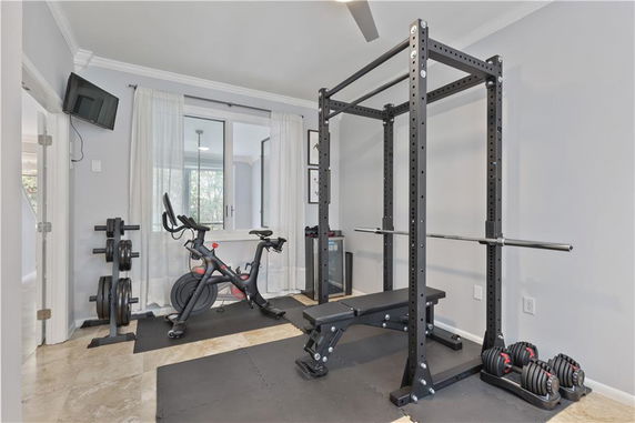 Home gym area with exercise equipment including a bike, squat rack, and weights.