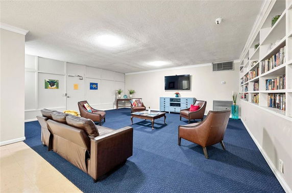 Common area with seating, television, and bookshelves.