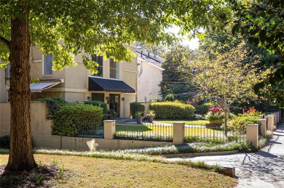 Front view of a house with two stories and a black awning over the entrance.