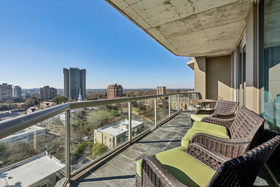 Panoramic view from a balcony showing city buildings and skyline.