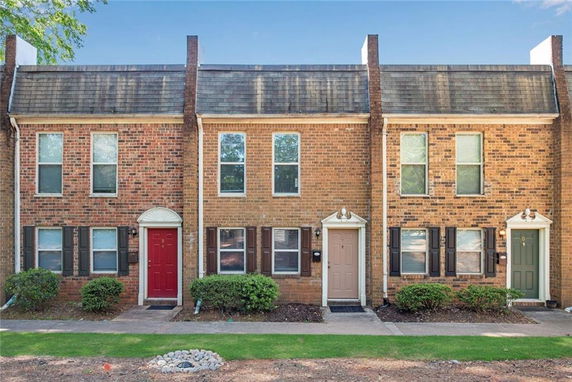 Front view of a row of brick townhouses with multiple entrances.