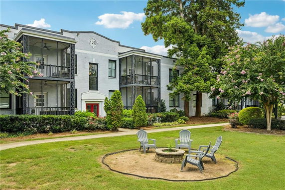 Front view of a two-story building with balconies and a garden area in front.