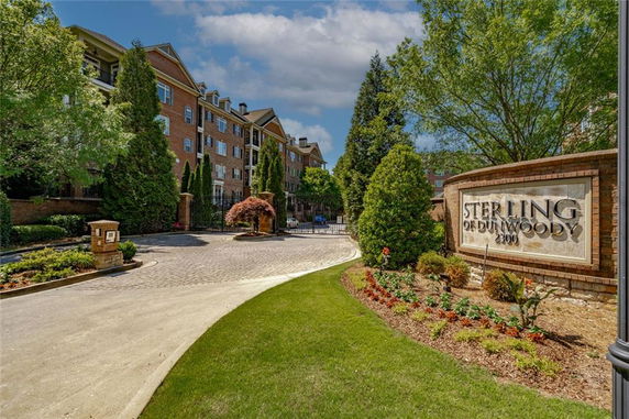 Front view of a multi-story residential building with a sign reading 'Sterling of Dunwoody.'