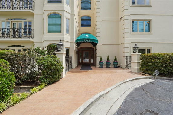 Front view of a multi-story building with decorative windows and green awning over the entrance.