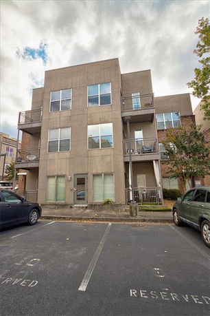 Front view of a three-story apartment building with balconies.