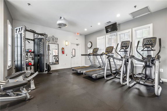 Indoor gym area with exercise equipment including treadmills and weight machines.